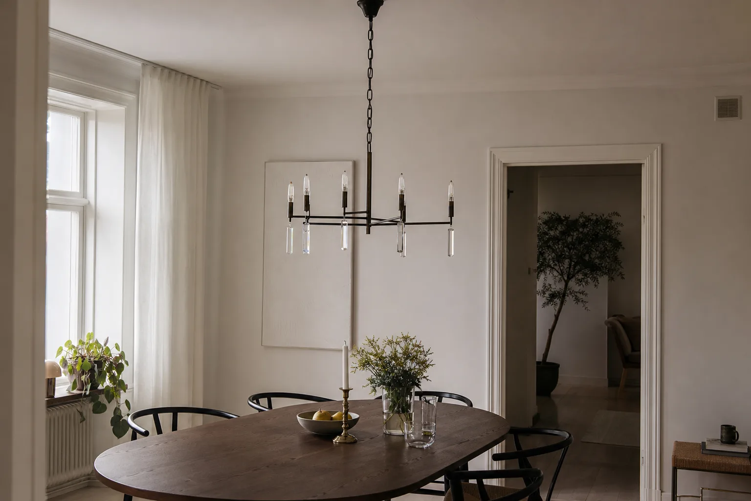 Modern mörk kristallkrona över ovalt bord