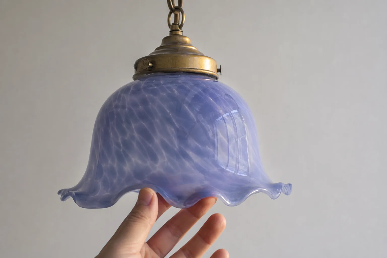 Närbild av färgat lampglas och metallinfästning